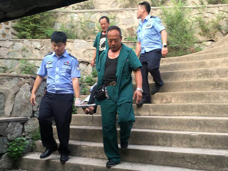 民警和急救人員將中暑男子抬上急救車(chē)